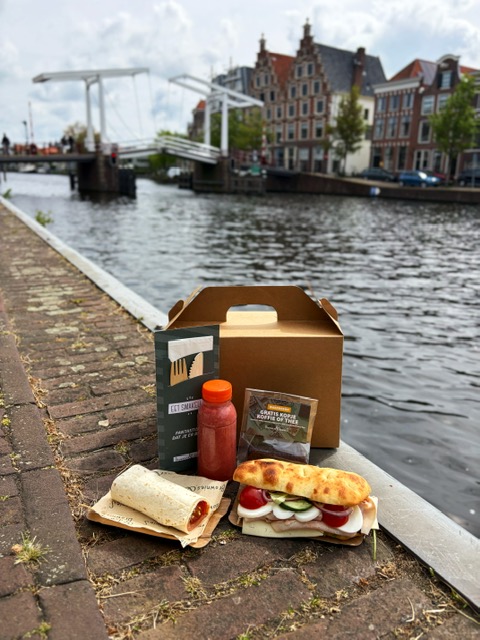 Focaccia, wrap, smoothie en brownie op een houten tafel